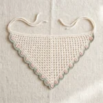 Ivory floral crochet bandana with sage-green scalloped edging, blush-pink flowers and ivory ties